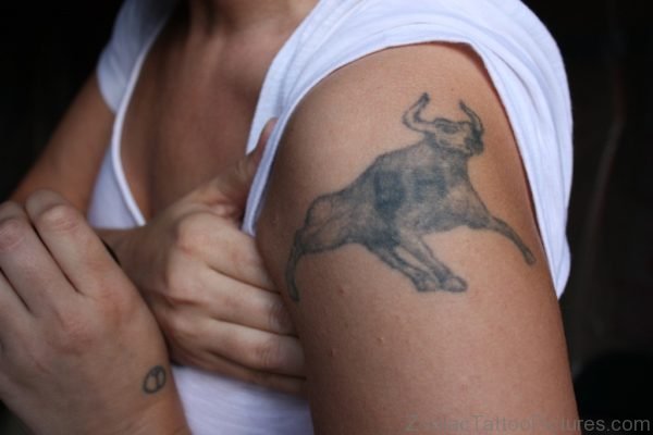Girl Showing Her Grey Bull Taurus Tattoo On Shoulder